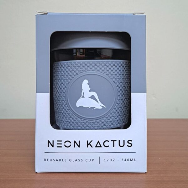 Reusable glass coffee cup in box. Grey silicone lid and sleeve with a white mermaid of the north logo