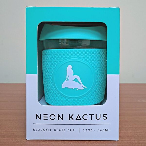 Reusable glass coffee cup in box. Turquoise silicone lid and sleeve with white mermaid of the north logo